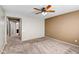 Bright bedroom with plush carpet, ceiling fan, and access to bathroom at 10789 W Saddlehorn Rd, Peoria, AZ 85383