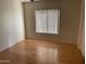 Bright bedroom featuring wood flooring and a large window at 1120 S 232Nd Ave, Buckeye, AZ 85326