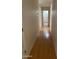 Long hallway with light wood flooring and access to bedrooms at 1120 S 232Nd Ave, Buckeye, AZ 85326