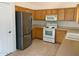 Kitchen features wood cabinets, stainless steel appliances, and tile floor at 1120 S 232Nd Ave, Buckeye, AZ 85326