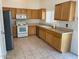 Kitchen boasts wood cabinets, stainless steel appliances, and tile flooring at 1120 S 232Nd Ave, Buckeye, AZ 85326