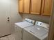 Bright laundry room, washer, dryer included, wood cabinets, and tile floor at 1120 S 232Nd Ave, Buckeye, AZ 85326
