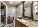 Bathroom with stone counter, wood cabinets, decorative mirror, and tiled walk-in shower at 11237 E Troon Mountain Dr, Scottsdale, AZ 85255