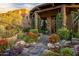 Inviting front entrance with stone pathway, lush landscaping, and a charming wooden door at 11237 E Troon Mountain Dr, Scottsdale, AZ 85255