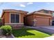 Beautiful one-story home with a landscaped lawn and two-car garage at 11719 W Planada Ct, Sun City, AZ 85373