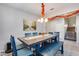 Dining area with rustic table, blue chairs, and bench; view of stairs at 14428 W Faye Way, Surprise, AZ 85387