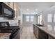 Gray cabinets, granite countertops, and stainless steel appliances in this kitchen at 14428 W Faye Way, Surprise, AZ 85387