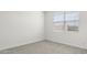 Bright bedroom with neutral walls and carpet, featuring a window with blinds at 1615 S 239Th Dr, Buckeye, AZ 85326