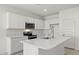Modern kitchen features white cabinets, stainless steel appliances, and an island at 1615 S 239Th Dr, Buckeye, AZ 85326