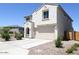 Two-story house with tan exterior, two-car garage, and desert landscaping at 1702 W Flintlock Dr, San Tan Valley, AZ 85144
