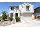 Two-story house with tan exterior, two-car garage, and desert landscaping at 1702 W Flintlock Dr, San Tan Valley, AZ 85144