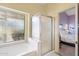 Bathroom with shower, bathtub, and view into bedroom at 18431 N Coconino Dr, Surprise, AZ 85374