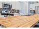 Large kitchen island with butcher block countertop and stainless steel appliances at 18956 W Laurel Ln, Surprise, AZ 85388