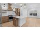 Bright open kitchen featuring a center island, stainless steel appliances, tile backsplash, and modern lighting at 20316 W Turney Ave, Buckeye, AZ 85396