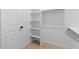 Well-organized walk-in closet with white shelving and a door at 20316 W Turney Ave, Buckeye, AZ 85396