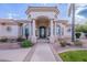 Elegant entryway with columns, a wrought-iron door, and a stone walkway at 4135 E Hale Cir, Mesa, AZ 85205