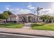 Single-story home with a tile roof, lush landscaping, and a welcoming front porch at 4135 E Hale Cir, Mesa, AZ 85205