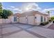 View of a three-car garage with decorative garage doors and a paved driveway at 4135 E Hale Cir, Mesa, AZ 85205