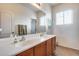 Bathroom with double sinks, large mirror, and tile floor at 44192 W Canyon Creek Dr, Maricopa, AZ 85139