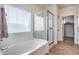 Bathroom with soaking tub, shower, and linen closet at 44192 W Canyon Creek Dr, Maricopa, AZ 85139