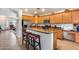 Open kitchen with island seating and light wood cabinets at 44192 W Canyon Creek Dr, Maricopa, AZ 85139