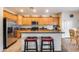 Kitchen with island, wood cabinetry, and stainless steel appliances at 44192 W Canyon Creek Dr, Maricopa, AZ 85139