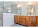Modern bathroom with dual sinks, wood cabinets, and glass shower at 5112 N 35Th St, Phoenix, AZ 85018