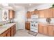 Bright kitchen with wood cabinets, white appliances, and tile floor at 5450 E Mclellan Rd # 234, Mesa, AZ 85205