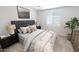 Bedroom with gray upholstered bed, nightstands, and large window at 10184 S Bickwell Trl, Apache Junction, AZ 85120