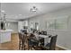 Bright dining room with a wood table, modern lighting, and access to kitchen at 12424 W Bluestem Dr, Sun City West, AZ 85375