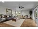 Living room with hardwood floors, leather couch, and large windows at 12424 W Bluestem Dr, Sun City West, AZ 85375