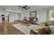 Living room with hardwood floors, ceiling fan, and view into kitchen at 12424 W Bluestem Dr, Sun City West, AZ 85375