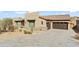 Front view of a house featuring a large garage and desert landscaping at 13222 E Ranch Gate Rd, Scottsdale, AZ 85255