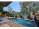 Beautiful backyard featuring a refreshing pool, lush landscaping, and a brick patio at 1325 W Lynwood St, Phoenix, AZ 85007