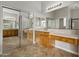 Bathroom with double vanity, wood cabinets, and a large mirror at 13813 W Monterey Way, Avondale, AZ 85392