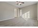 Bedroom with neutral carpeting, ceiling fan and door to patio at 13813 W Monterey Way, Avondale, AZ 85392