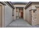 Front entry with a stone accent wall and a wooden door at 13813 W Monterey Way, Avondale, AZ 85392