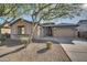 House exterior showcasing a two-car garage and mature tree in the front yard at 13813 W Monterey Way, Avondale, AZ 85392