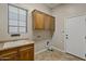 Laundry room with wooden cabinets, sink, and built-in storage at 13813 W Monterey Way, Avondale, AZ 85392