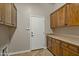 Laundry room with ample wooden cabinets and countertop space at 13813 W Monterey Way, Avondale, AZ 85392