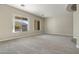 Bright living room featuring large windows and carpeted floors at 13813 W Monterey Way, Avondale, AZ 85392