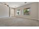 Living room featuring neutral carpet and multiple windows at 13813 W Monterey Way, Avondale, AZ 85392