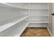 Walk-in pantry with white shelves and tile flooring at 13813 W Monterey Way, Avondale, AZ 85392