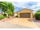 Tan house with a brown garage door and nicely landscaped yard at 13827 W Junipero Dr, Sun City West, AZ 85375