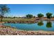 Golf course with pond and strategically placed trees at 13827 W Junipero Dr, Sun City West, AZ 85375