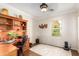 Home office with wood desk, built-in shelves, and window at 13827 W Junipero Dr, Sun City West, AZ 85375