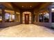 Elegant entryway with a stained-glass door, columns, and warm lighting at night at 14216 S Canyon Dr, Phoenix, AZ 85048