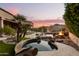 Hot tub with stone border and fire pit at sunset at 14216 S Canyon Dr, Phoenix, AZ 85048