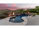 Luxury pool with fire pit and waterfall feature at sunset at 14216 S Canyon Dr, Phoenix, AZ 85048