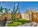 Landscaped backyard with cacti, artificial turf, and a wooden gate at 14731 W Trading Post Dr, Sun City West, AZ 85375